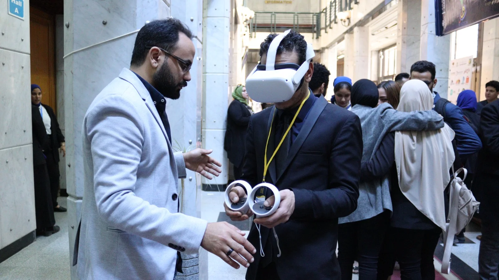 عضو من فريق ميتالايف يرشد زائرًا أثناء تجربة الواقع الافتراضي في جامعة القاهرة