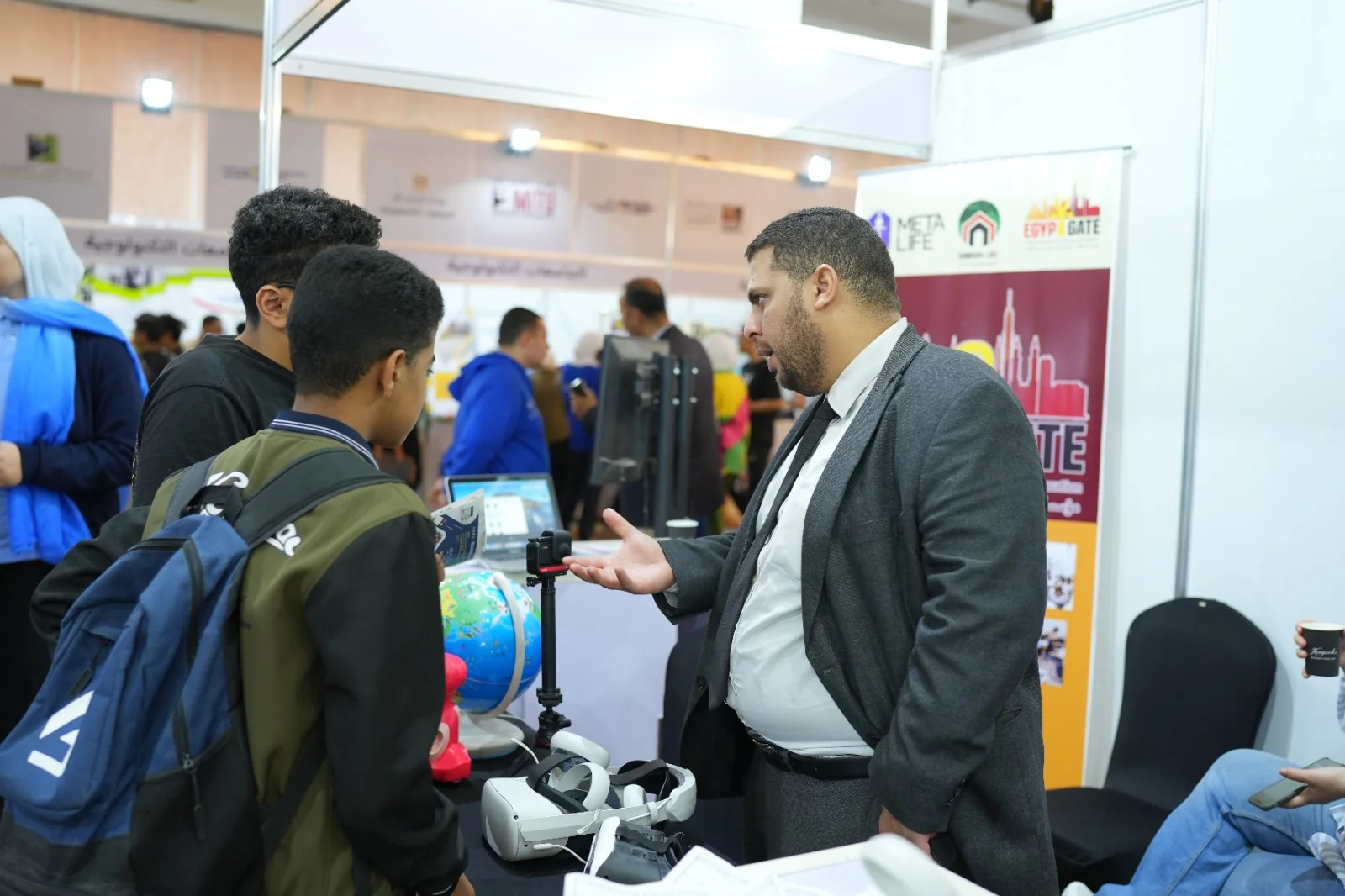 عضو من فريق ميتالايف يشرح لطلاب الكاميرا 360 ونظارات الواقع الافتراضي في أحد المعارض