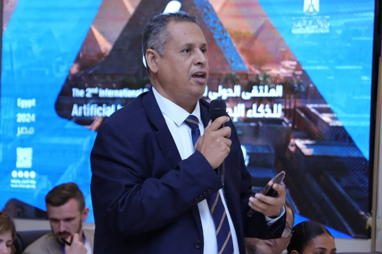 أحد المتحدثين أمام شاشة الملتقى، الملتقى الدولي الثاني للذكاء الاصطناعي بالقاهرة 2024
